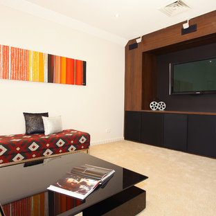 Example of a mid-sized trendy open concept carpeted home theater design in Gold Coast - Tweed with beige walls and a media wall