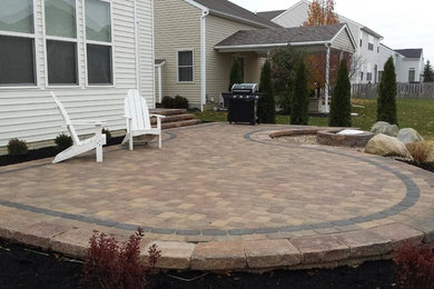 Example of a mid-sized classic backyard concrete paver patio design in Columbus with a fire pit and no cover
