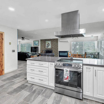 Coastal-Inspired White Kitchen with Blue Tile Backsplash and Porcelain Flooring