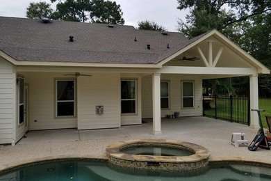 Inspiration for a mid-sized timeless backyard concrete patio remodel in Houston with a roof extension