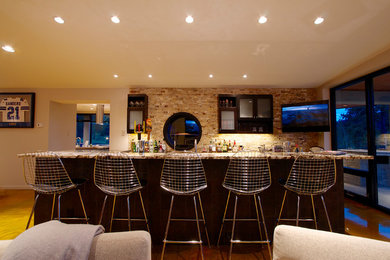 Inspiration for a modern u-shaped seated home bar remodel in Denver