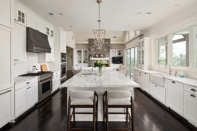 Example of a mid-sized classic galley dark wood floor and brown floor eat-in kitchen design in Atlanta with a farmhouse sink, shaker cabinets, white cabinets, quartzite countertops, white backsplash, subway tile backsplash, stainless steel appliances, an island and white countertops
