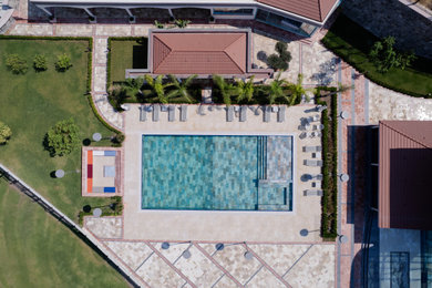 Backyard tile and rectangular pool photo in Other