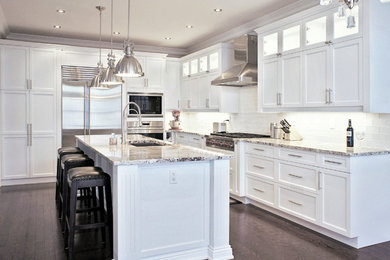 Large transitional l-shaped medium tone wood floor open concept kitchen photo in Toronto with an undermount sink, recessed-panel cabinets, white cabinets, granite countertops, white backsplash, glass tile backsplash, stainless steel appliances and an island