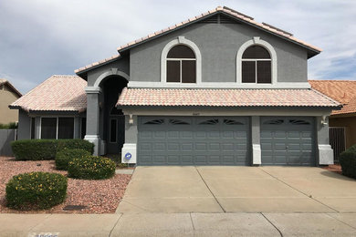 Large transitional gray two-story stucco exterior home idea in Phoenix with a tile roof