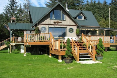 Large mountain style brown two-story wood exterior home photo in Other with a metal roof