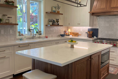 Large transitional u-shaped dark wood floor and brown floor eat-in kitchen photo in Los Angeles with an undermount sink, recessed-panel cabinets, quartz countertops, gray backsplash, porcelain backsplash, stainless steel appliances, an island and white countertops