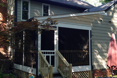 This is an example of a mid-sized traditional screened-in back porch design in Richmond with decking and a roof extension.