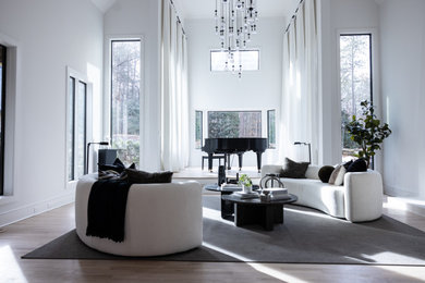 Imagen de salón para visitas abierto minimalista grande con paredes blancas, suelo de madera clara, marco de chimenea de hormigón y suelo amarillo