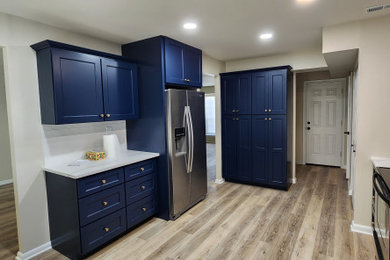 Kitchen - large traditional vinyl floor and beige floor kitchen idea in Philadelphia with a drop-in sink, blue cabinets, quartz countertops, white backsplash, cement tile backsplash, stainless steel appliances, an island and white countertops