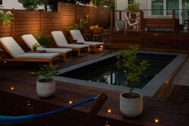 Diseño de terraza planta baja moderna de tamaño medio en patio trasero con barandilla de cable