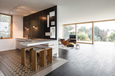Small modern l-shaped open plan kitchen in Other with a built-in sink, flat-panel cabinets, white cabinets, stainless steel appliances, a breakfast bar and white worktops.