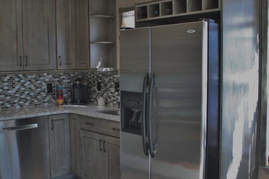 Small transitional u-shaped ceramic tile kitchen photo in Charlotte with no island, flat-panel cabinets, distressed cabinets, granite countertops, gray backsplash, mosaic tile backsplash, stainless steel appliances and an undermount sink