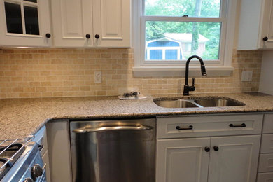 Example of a mid-sized classic l-shaped porcelain tile eat-in kitchen design in Other with an undermount sink, raised-panel cabinets, white cabinets, granite countertops, beige backsplash, stone tile backsplash, stainless steel appliances and an island