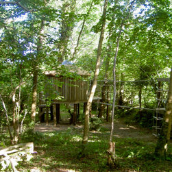 Treetop walkway going through the canopy towards a hidden thatched treehouse. - Garden Playhouses