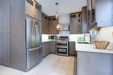 Inspiration for a mid-sized contemporary u-shaped porcelain tile and gray floor eat-in kitchen remodel in Toronto with an undermount sink, flat-panel cabinets, gray cabinets, quartz countertops, white backsplash, porcelain backsplash, stainless steel appliances, no island and white countertops