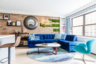Eclectic light wood floor and brick wall living room photo in New York