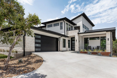 Inspiration for a contemporary white two-story stucco house exterior remodel in Austin with a metal roof and a black roof