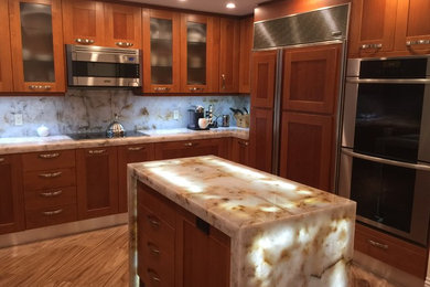 Kitchen pantry - mid-sized traditional l-shaped light wood floor kitchen pantry idea in Other with shaker cabinets, medium tone wood cabinets, granite countertops, multicolored backsplash, stone tile backsplash, stainless steel appliances and an island