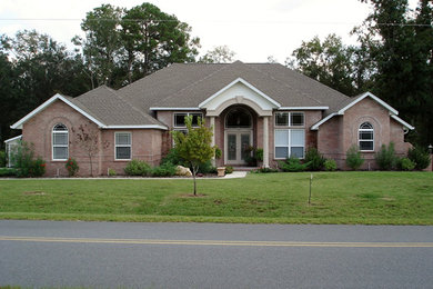 Large red one-story brick exterior home idea in Jacksonville