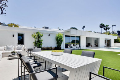 Inspiration for a large contemporary white one-story stucco exterior home remodel in Los Angeles with a mixed material roof