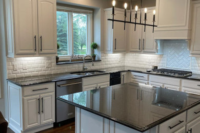 Inspiration for a mid-sized modern kitchen remodel in Detroit with white cabinets, granite countertops, white backsplash, brick backsplash, an island and black countertops
