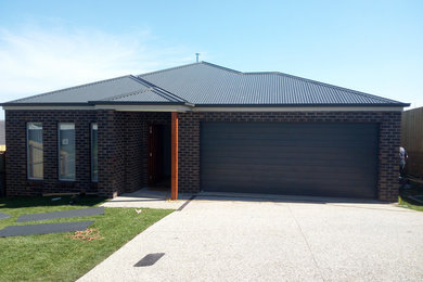 This is an example of a modern house exterior in Other with a gable roof and a metal roof.