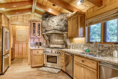 Example of a mid-sized mountain style u-shaped medium tone wood floor, brown floor and vaulted ceiling eat-in kitchen design in San Francisco with a double-bowl sink, shaker cabinets, medium tone wood cabinets, granite countertops, multicolored backsplash, granite backsplash, stainless steel appliances, an island and multicolored countertops
