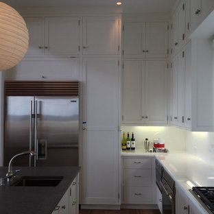 Large tropical l-shaped kitchen pantry in Other with an undermount sink, shaker cabinets, white cabinets, wood benchtops, stainless steel appliances, medium hardwood floors, with island and beige floor.