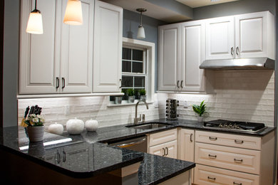 Small transitional u-shaped medium tone wood floor and brown floor open concept kitchen photo in St Louis with an undermount sink, raised-panel cabinets, white cabinets, granite countertops, white backsplash, ceramic backsplash, stainless steel appliances and a peninsula