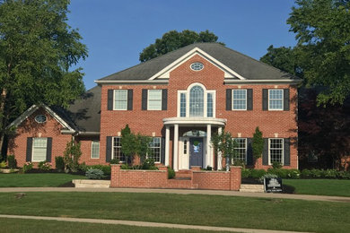 Photo of a large traditional full sun front yard brick retaining wall landscape in Other.