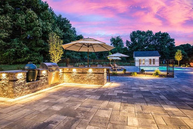 Inspiration for a modern backyard stone patio kitchen remodel in Bridgeport with an awning