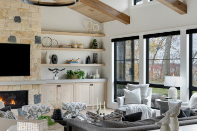 Inspiration for a huge transitional open concept exposed beam and wall paneling living room remodel in Minneapolis with white walls, a standard fireplace, a stacked stone fireplace and a wall-mounted tv