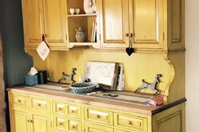 Eat-in kitchen - mid-sized country l-shaped medium tone wood floor eat-in kitchen idea in Salt Lake City with a farmhouse sink, beaded inset cabinets, yellow cabinets, wood countertops, stone slab backsplash, stainless steel appliances and an island