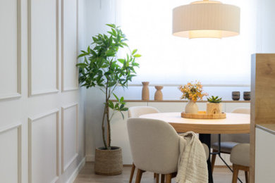Imagen de comedor escandinavo de tamaño medio con paredes blancas, suelo de madera clara, panelado y cortinas