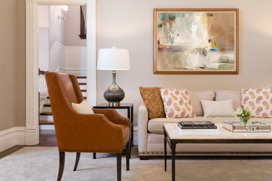 Example of a large transitional open concept medium tone wood floor, brown floor, vaulted ceiling and wainscoting living room design in San Francisco with beige walls, a hanging fireplace and a wood fireplace surround