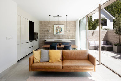 Design ideas for a medium sized contemporary kitchen/diner in London with an island, a double-bowl sink, flat-panel cabinets, black cabinets, quartz worktops, stainless steel appliances, porcelain flooring, grey floors, white worktops and a feature wall.