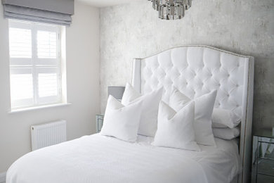 Imagen de dormitorio principal y gris y blanco moderno grande con paredes grises, moqueta, suelo gris y papel pintado