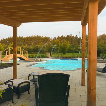 Pool with a firepit by Exact Landscapes