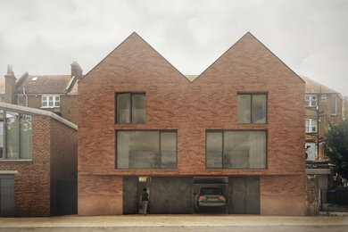 This is an example of a large and red coastal brick and front house exterior in London with three floors, a butterfly roof, a tiled roof, a red roof and shingles.