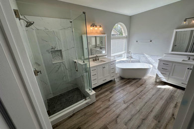 Large master white tile and marble tile vinyl floor, brown floor and double-sink bathroom photo in Austin with gray walls, an undermount sink, quartz countertops, a hinged shower door, white countertops, a niche and a built-in vanity