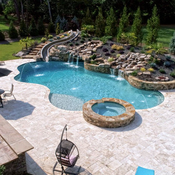 Large Custom Freeform pool with Slide, Grotto, Waterfall, and Travertine