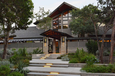 Example of a huge trendy limestone floor, gray floor and exposed beam entryway design in Austin with gray walls and a black front door