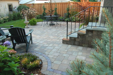 Traditional backyard patio in Minneapolis with concrete pavers.