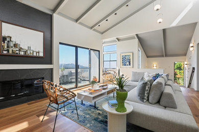 Living room - large contemporary open concept light wood floor and vaulted ceiling living room idea in San Francisco with white walls, a standard fireplace and a stone fireplace