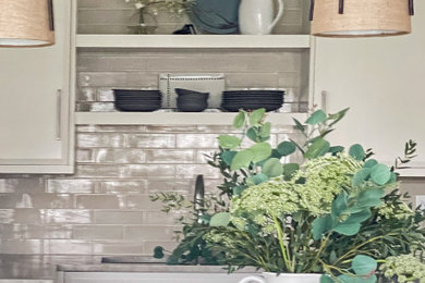Inspiration for a mid-sized coastal u-shaped vinyl floor and beige floor kitchen remodel in Other with a double-bowl sink, flat-panel cabinets, white cabinets, quartzite countertops, beige backsplash, cement tile backsplash, stainless steel appliances and beige countertops