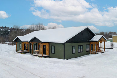 Inspiration for a large cottage green one-story wood and clapboard exterior home remodel in Burlington with a shingle roof and a black roof