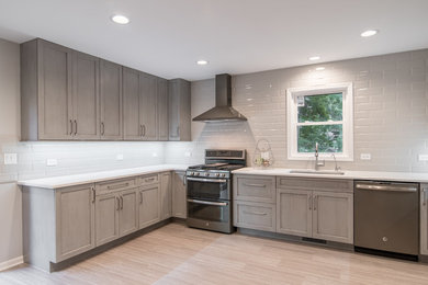 Enclosed kitchen - mid-sized transitional u-shaped vinyl floor and gray floor enclosed kitchen idea in Chicago with an undermount sink, recessed-panel cabinets, gray cabinets, quartzite countertops, gray backsplash, ceramic backsplash, stainless steel appliances and no island