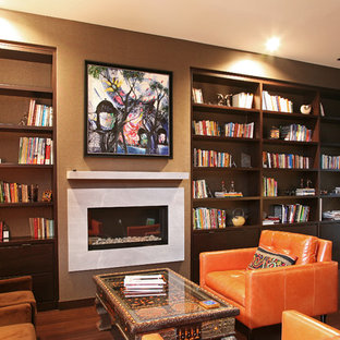 Large modern home office and library in Boston with a reading nook, grey walls, dark hardwood flooring, a ribbon fireplace, a stone fireplace surround and a freestanding desk.