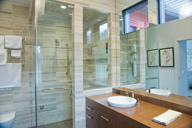 Walk-in shower - mid-sized modern master porcelain tile and brown floor walk-in shower idea in Boston with flat-panel cabinets, medium tone wood cabinets, wood countertops, white walls and a hinged shower door